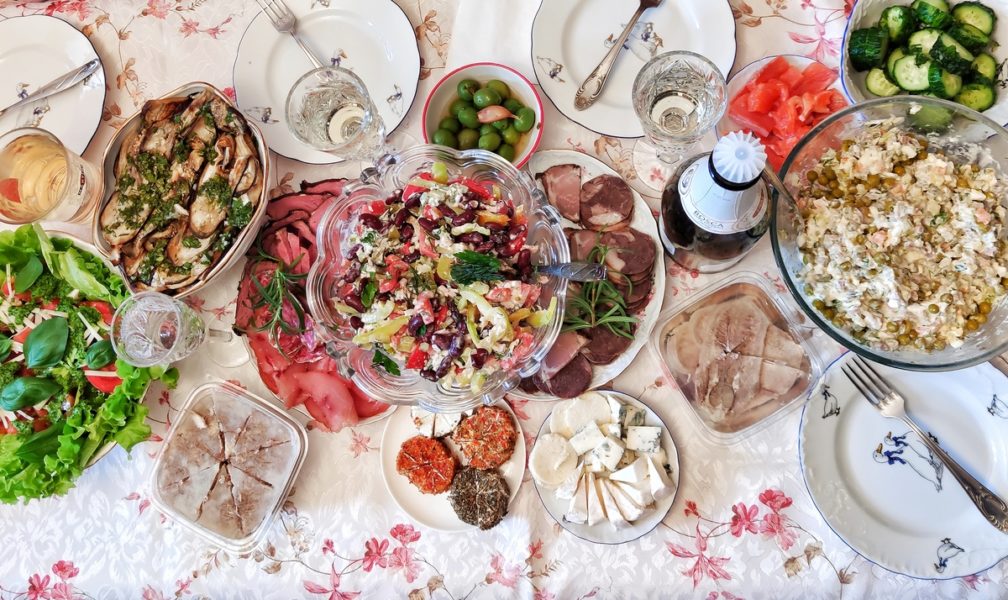 домашний праздничный стол с салатами, закусками и шампанским
